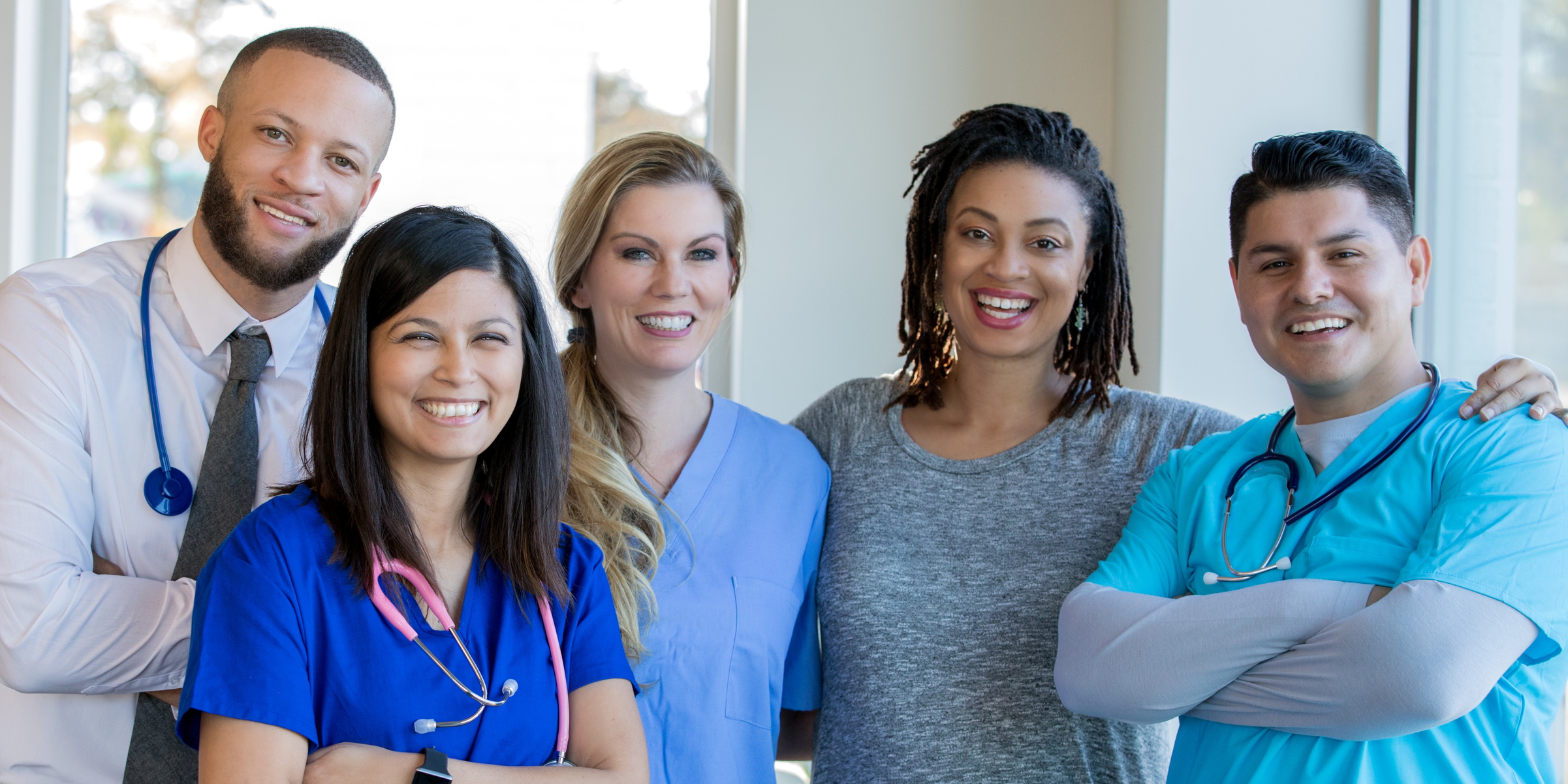 Diverse healthcare team of doctors and nurses standing in hospital hallway